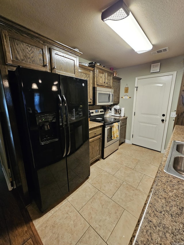513 Saint Charles Ct, Haskell, AR 72015 - kitchen with stainless steel appliances, a textured ceiling, a sink, light countertops, and light tile patterned floors