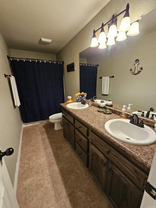 bathroom featuring tile patterned flooring, vanity, toilet, and a textured ceiling