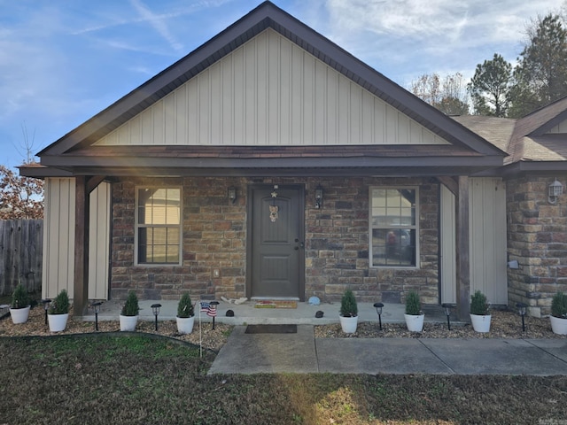 513 Saint Charles Ct, Haskell, AR 72015 - view of front facade featuring board and batten siding, stone siding, and covered porch