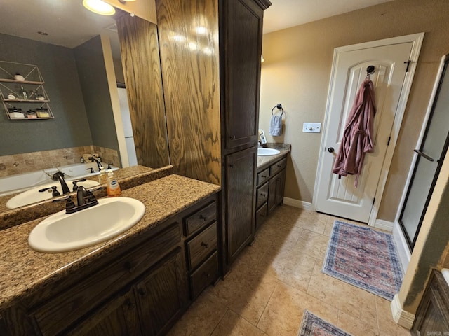 bathroom with tile patterned flooring, a washtub, and vanity