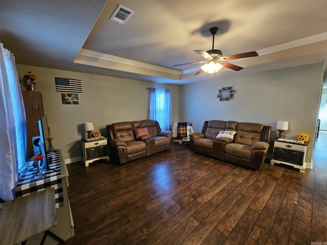 living room featuring ceiling fan, crown molding, a raised ceiling, and dark hardwood / wood-style flooring