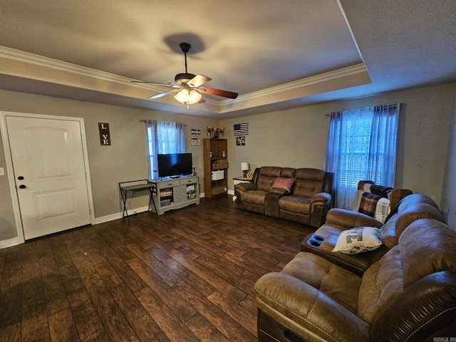 living room with dark hardwood / wood-style flooring, ceiling fan, a raised ceiling, and plenty of natural light