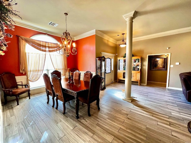 dining space with ornate columns, crown molding, light hardwood / wood-style flooring, and a notable chandelier