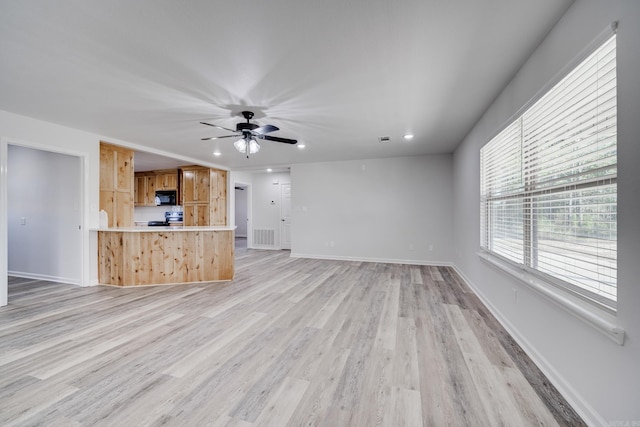 unfurnished living room with light wood-type flooring and ceiling fan