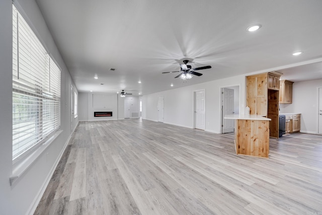 unfurnished living room with a fireplace, ceiling fan, and light hardwood / wood-style flooring