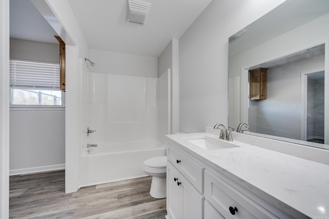 full bathroom featuring hardwood / wood-style flooring, vanity, toilet, and tub / shower combination