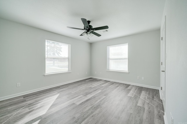 unfurnished room featuring plenty of natural light, ceiling fan, and light hardwood / wood-style flooring