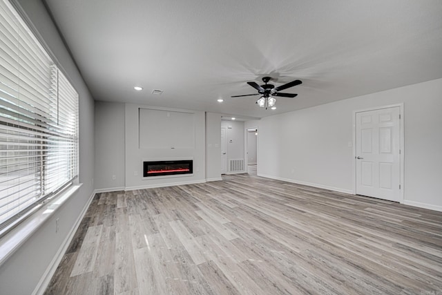 unfurnished living room with ceiling fan and light wood-type flooring