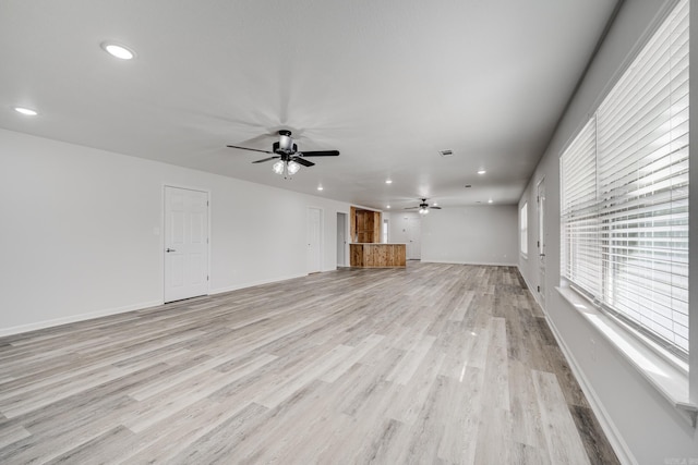 unfurnished living room with ceiling fan and light hardwood / wood-style flooring