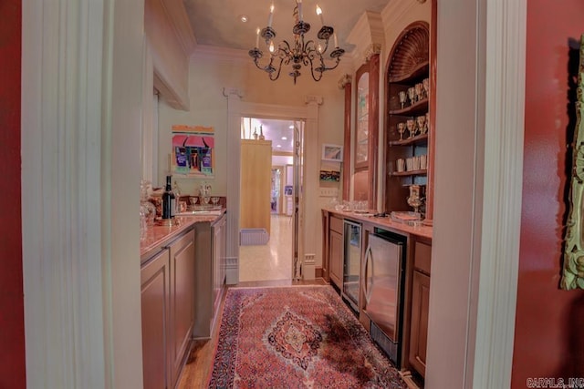 bar with wine cooler, light wood-type flooring, light stone counters, and ornamental molding