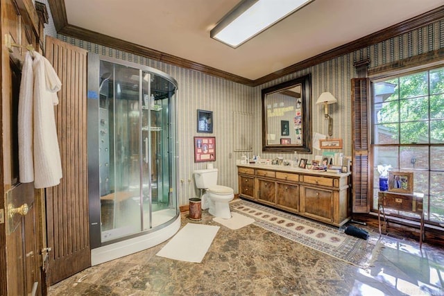 bathroom with toilet, vanity, a shower with door, and crown molding