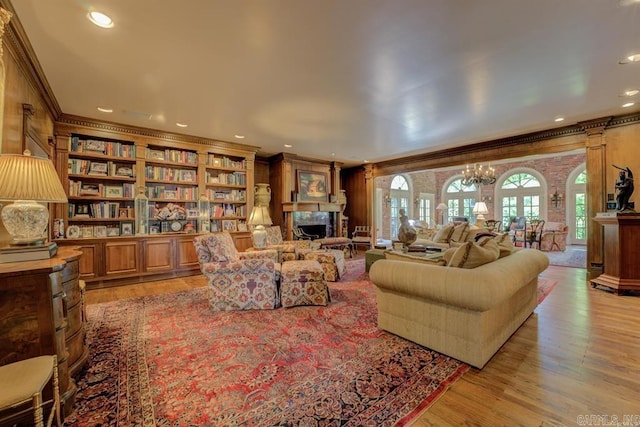 living room featuring light hardwood / wood-style floors, an inviting chandelier, and ornamental molding