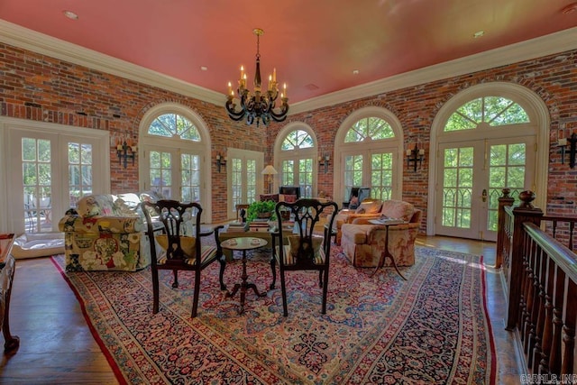 living room featuring french doors, a wealth of natural light, and brick wall