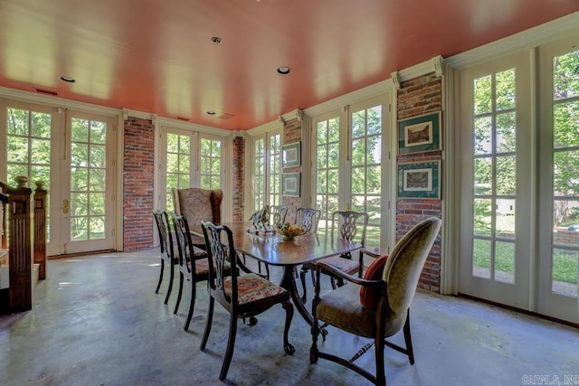 dining room featuring a wealth of natural light, french doors, and brick wall