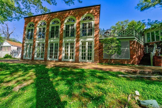 rear view of property featuring a lawn