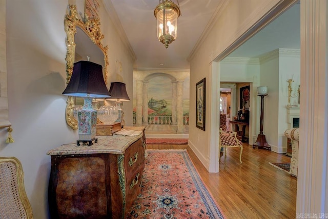 hallway with light wood-type flooring and crown molding