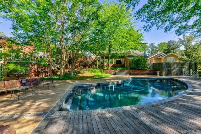 view of swimming pool featuring a patio and a deck