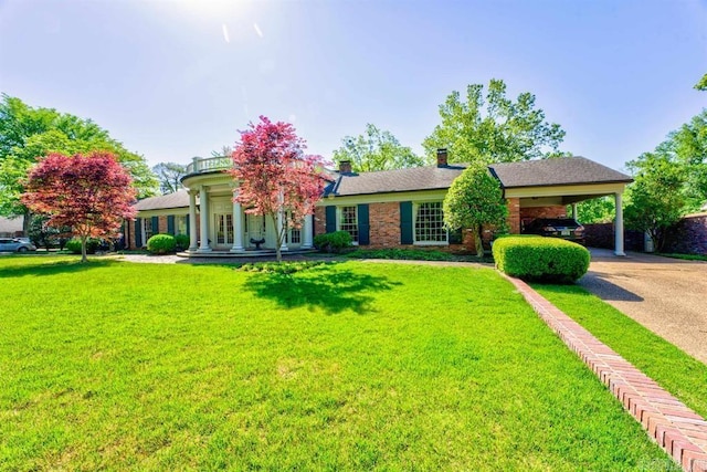 view of front of home with a front yard and a carport