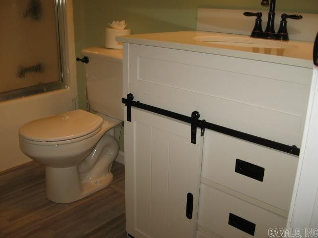 bathroom with hardwood / wood-style floors, vanity, and toilet