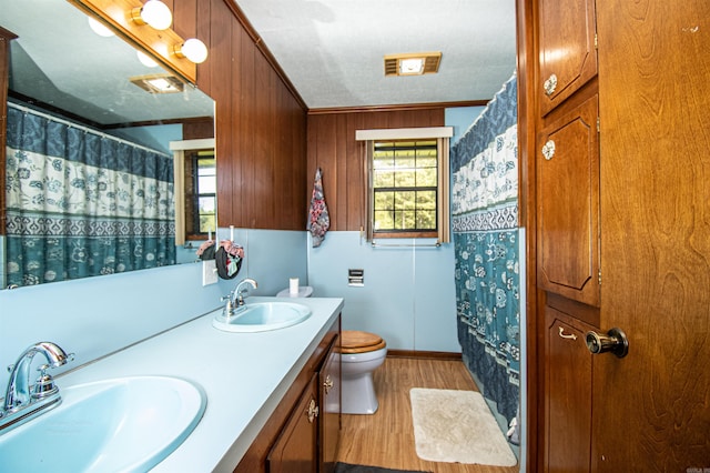 bathroom with ornamental molding, vanity, hardwood / wood-style flooring, and toilet