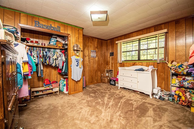 carpeted bedroom with wooden walls and a closet