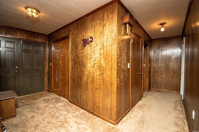 hall with wooden walls and light carpet