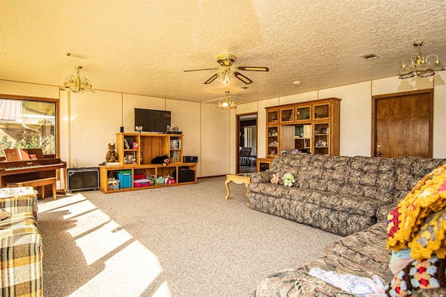 living room featuring carpet flooring, ceiling fan with notable chandelier, and a textured ceiling