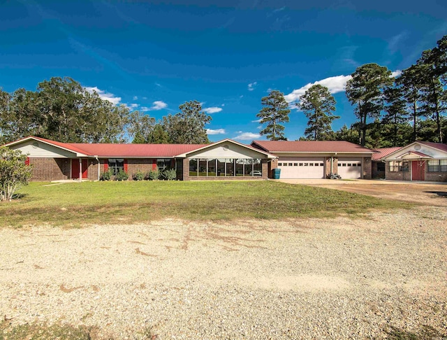 ranch-style house featuring a front lawn, a garage, and a sunroom