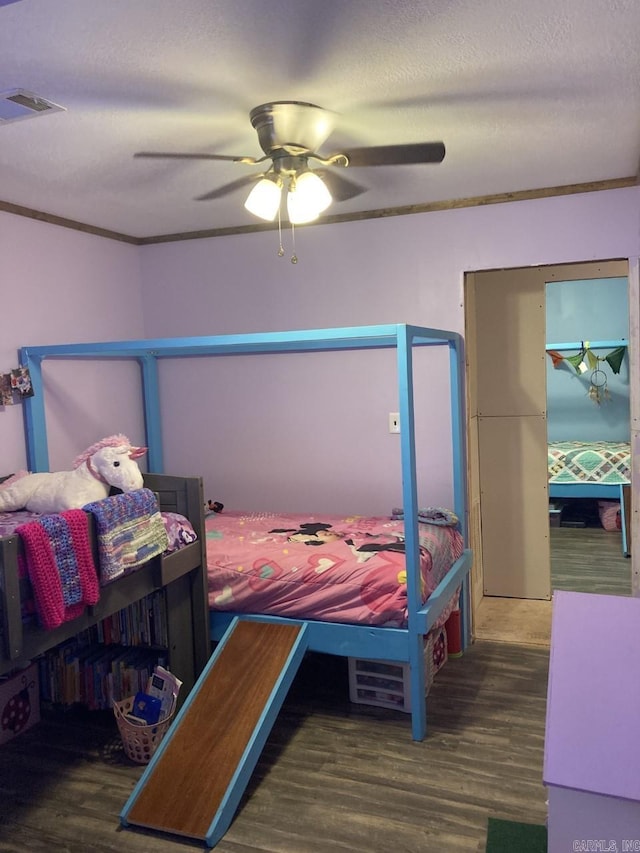 bedroom with crown molding, ceiling fan, and dark hardwood / wood-style floors