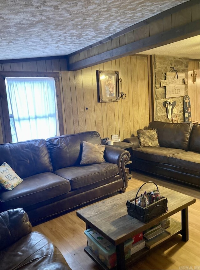 living room featuring hardwood / wood-style floors, a textured ceiling, and wooden walls