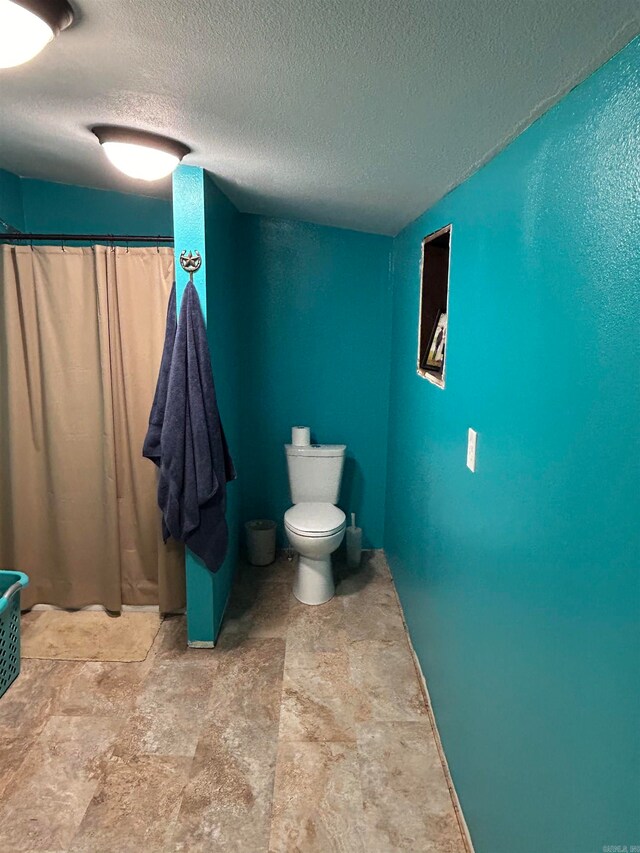 bathroom featuring a textured ceiling and toilet