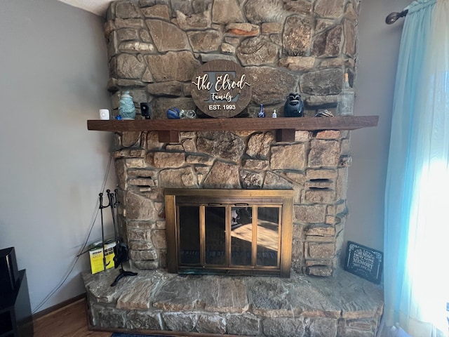 details featuring a stone fireplace and hardwood / wood-style flooring