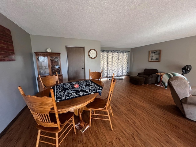 dining area with a textured ceiling and dark hardwood / wood-style floors