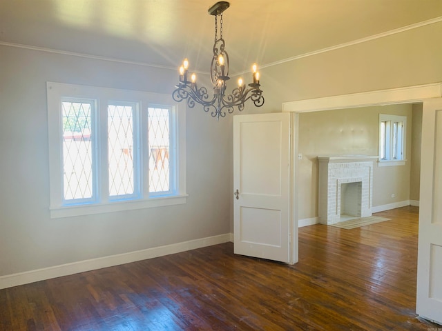 unfurnished dining area with a fireplace, dark hardwood / wood-style flooring, and a notable chandelier