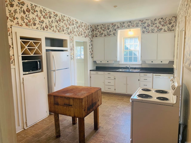 kitchen with white appliances, sink, and white cabinets