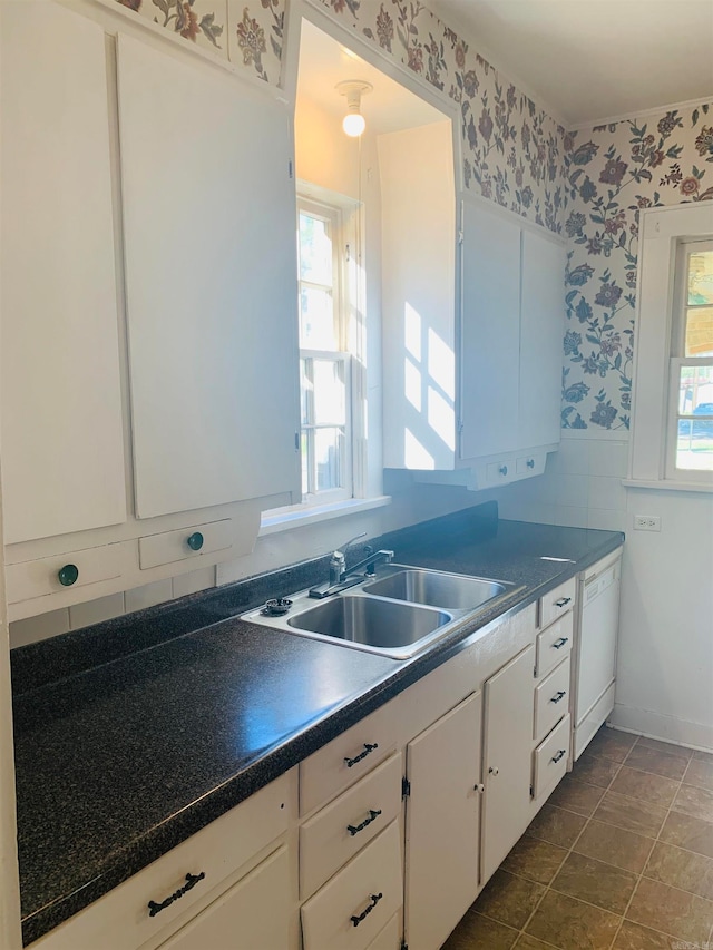 kitchen featuring white cabinets, sink, and white dishwasher