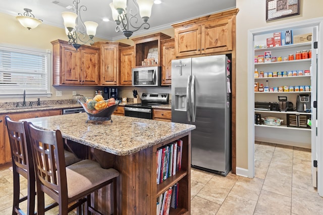 kitchen with stainless steel appliances, sink, an inviting chandelier, decorative light fixtures, and a center island