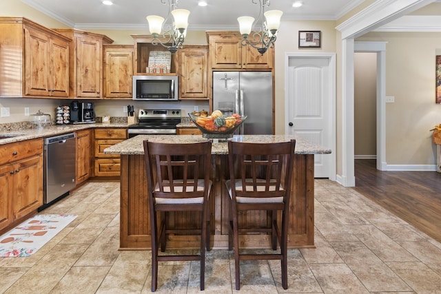 kitchen with pendant lighting, appliances with stainless steel finishes, a notable chandelier, and a center island