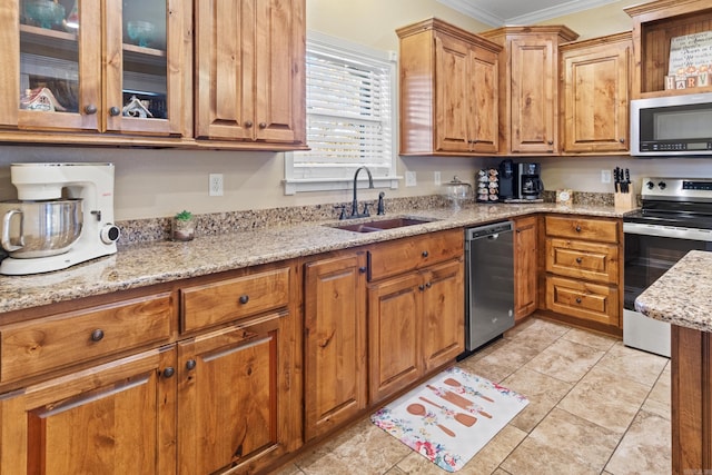 kitchen with stainless steel appliances, light tile patterned floors, sink, ornamental molding, and light stone countertops