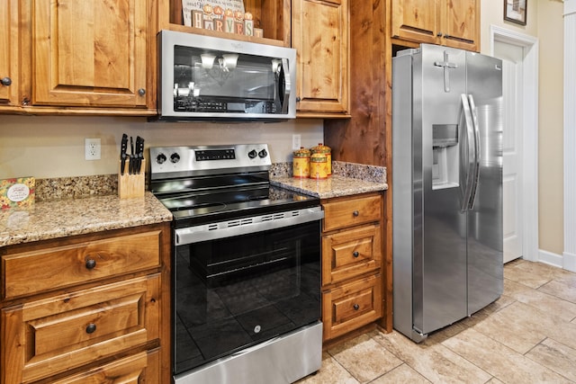 kitchen featuring light stone countertops and appliances with stainless steel finishes