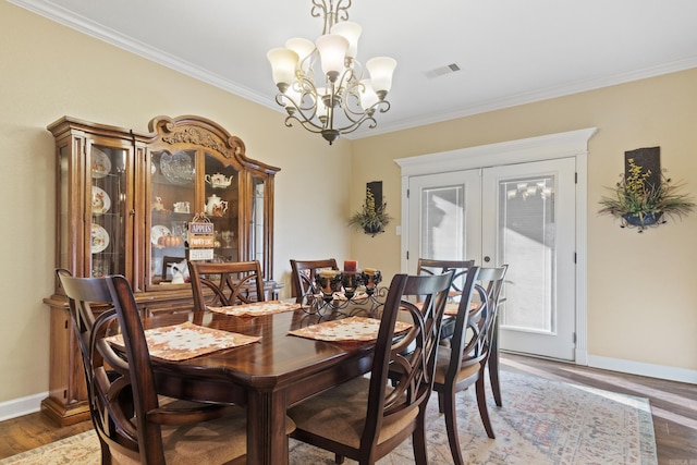 dining space featuring dark hardwood / wood-style flooring, a chandelier, and crown molding