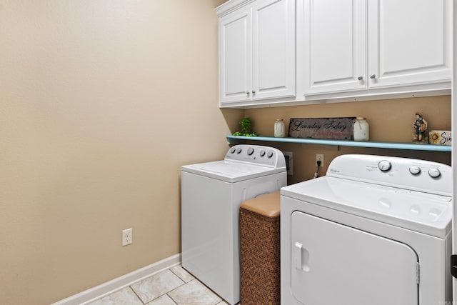 clothes washing area featuring cabinets, washer and dryer, and light tile patterned floors