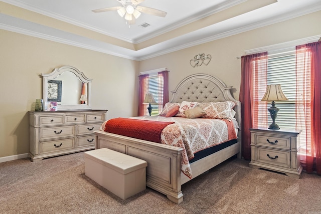 carpeted bedroom with ornamental molding, ceiling fan, and a raised ceiling