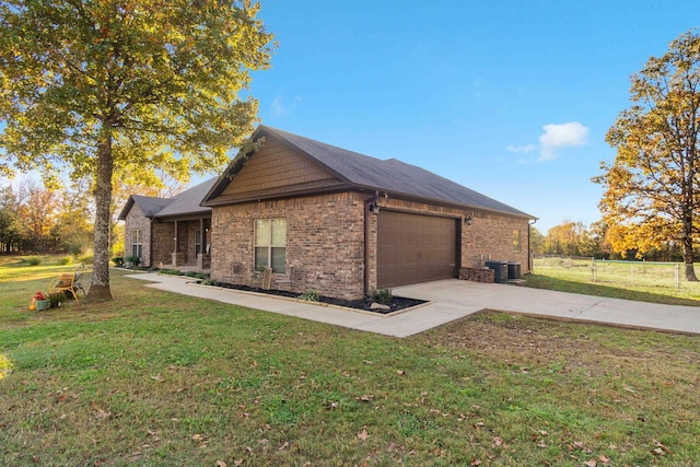 view of side of property with central AC unit, a garage, and a lawn