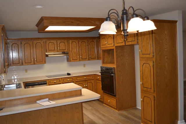 kitchen featuring kitchen peninsula, black appliances, sink, a notable chandelier, and light wood-type flooring