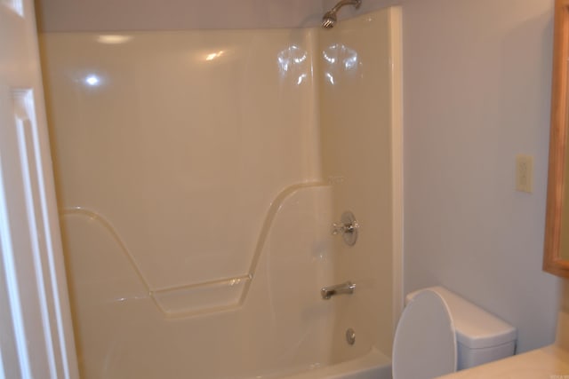 bathroom featuring shower / bathing tub combination and toilet