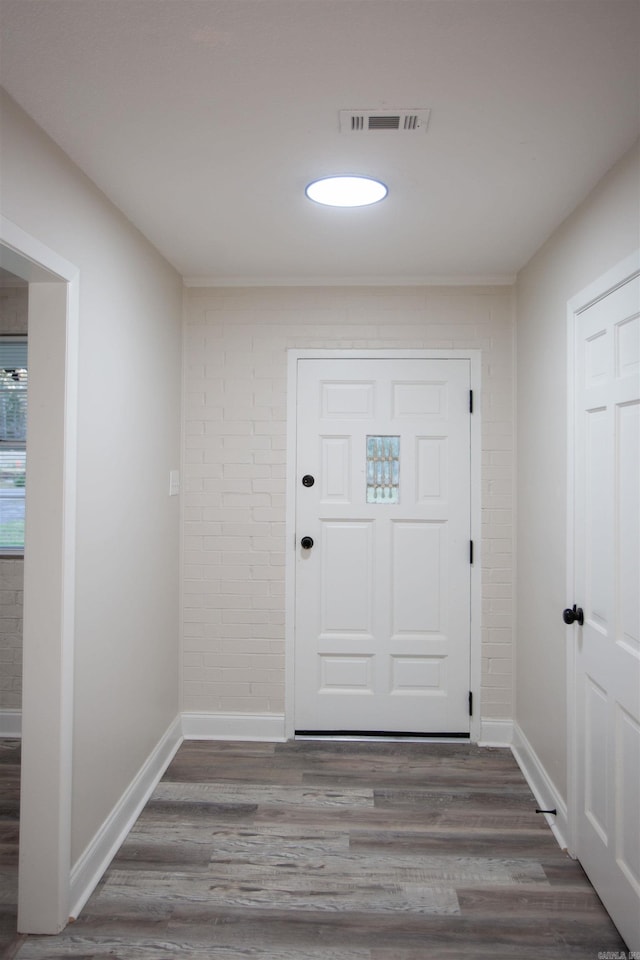 entryway with hardwood / wood-style flooring and brick wall