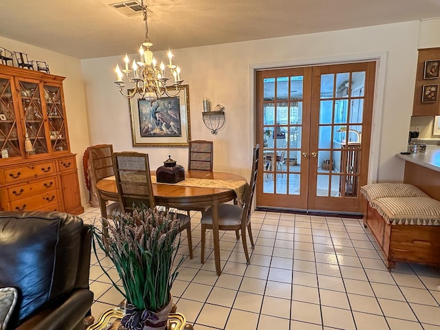 tiled dining area featuring french doors, a notable chandelier, and a textured ceiling