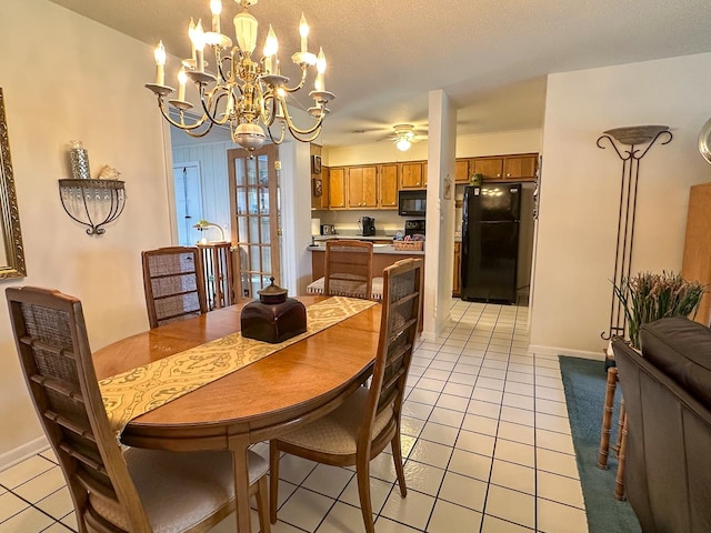 tiled dining area featuring ceiling fan with notable chandelier and a textured ceiling