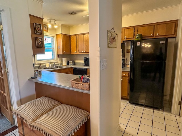 kitchen featuring black appliances, light tile patterned floors, crown molding, and sink